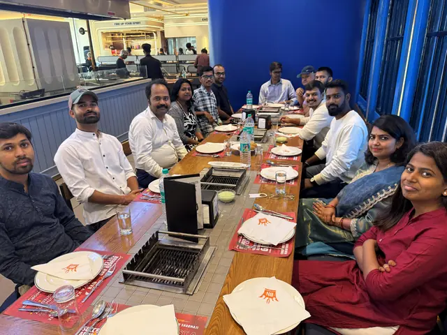 The team seated down both sides of a long table at a grill restaurant