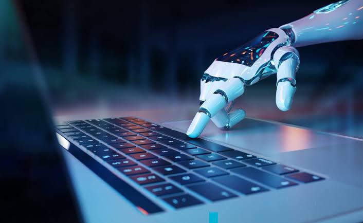 A robotic hand pressing a key on a laptop keyboard, representing automated test execution