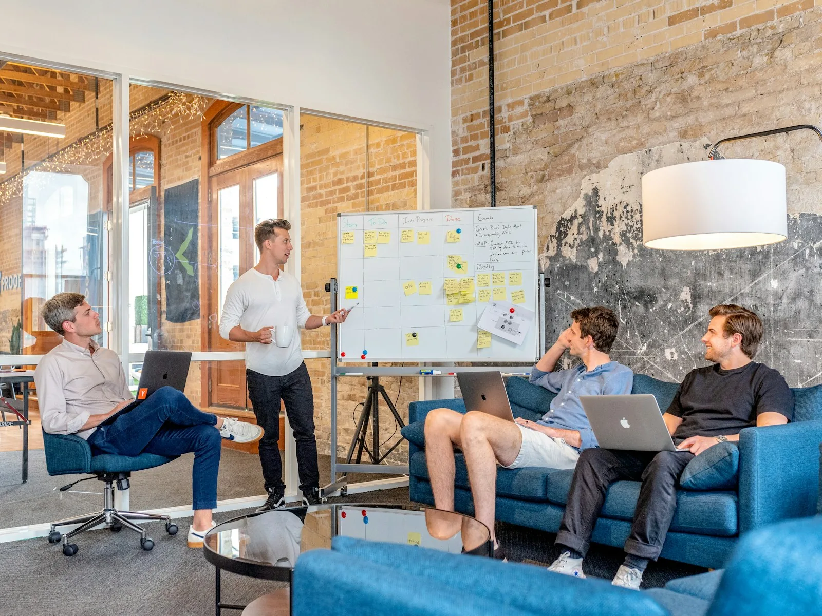 A team planning session in front of a whiteboard covered in sprint story cards